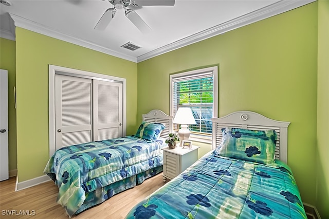 bedroom with a closet, light hardwood / wood-style flooring, ceiling fan, and crown molding