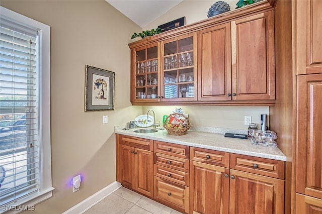 interior space with light tile patterned floors, sink, and vaulted ceiling