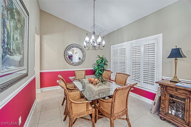 dining room with light tile patterned flooring, lofted ceiling, and a chandelier