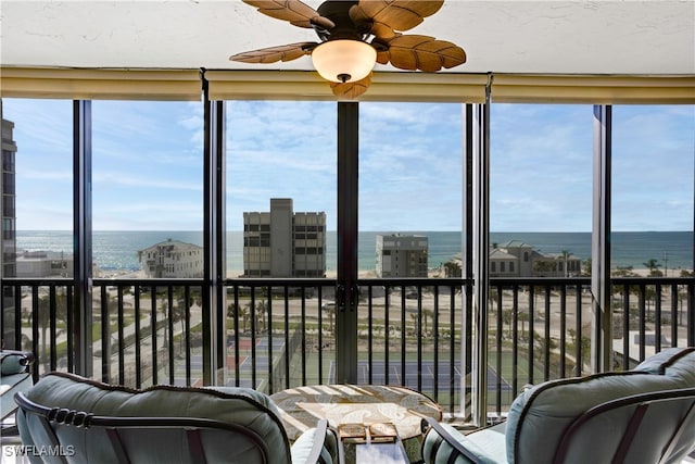 sunroom / solarium featuring ceiling fan, plenty of natural light, and a water view