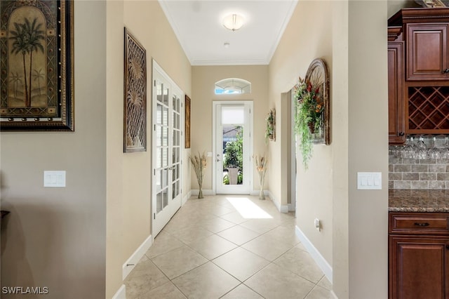 doorway with light tile patterned floors, french doors, and ornamental molding