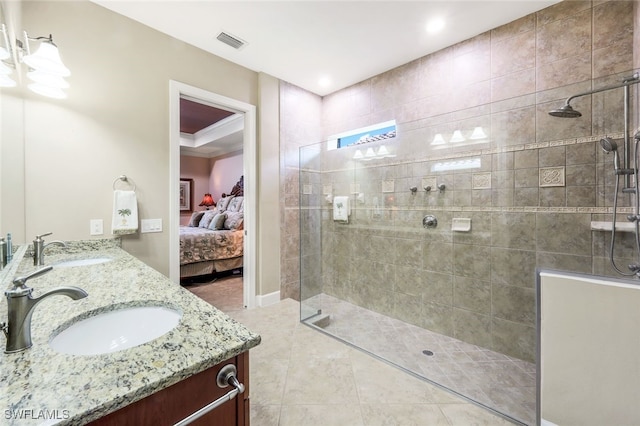 bathroom featuring tile patterned flooring, vanity, and tiled shower