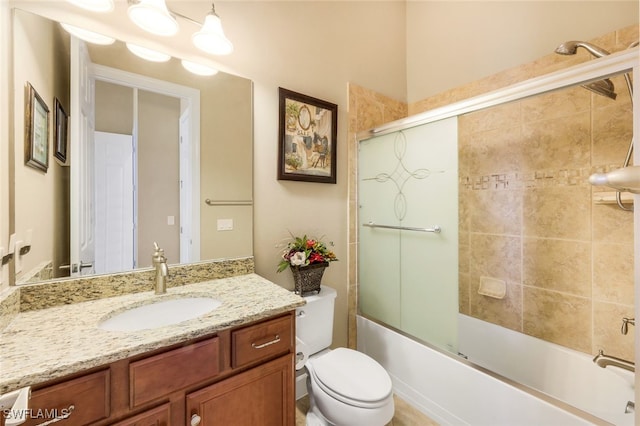 full bathroom featuring combined bath / shower with glass door, vanity, and toilet