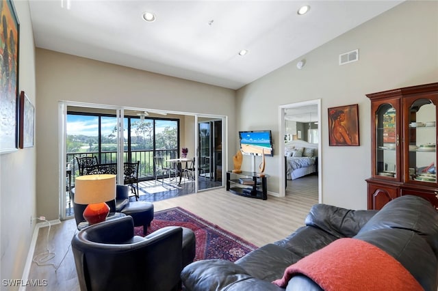 living room with lofted ceiling and light hardwood / wood-style flooring