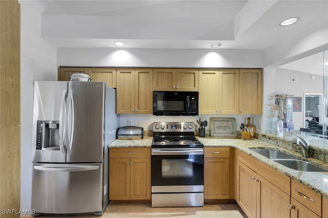 kitchen featuring light stone counters, appliances with stainless steel finishes, sink, and light tile patterned floors