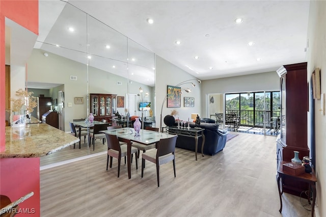 dining room with a high ceiling and light wood-type flooring