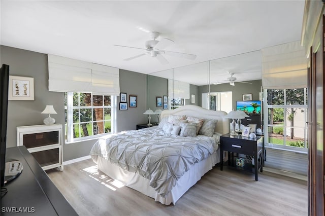 bedroom with multiple windows, wood-type flooring, and ceiling fan