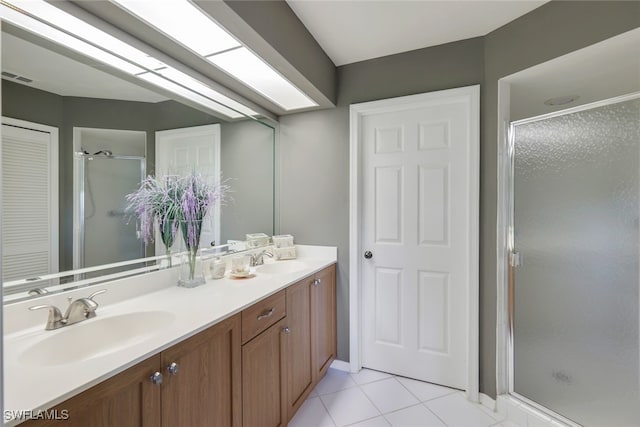 bathroom with tile patterned flooring, vanity, and a shower with door