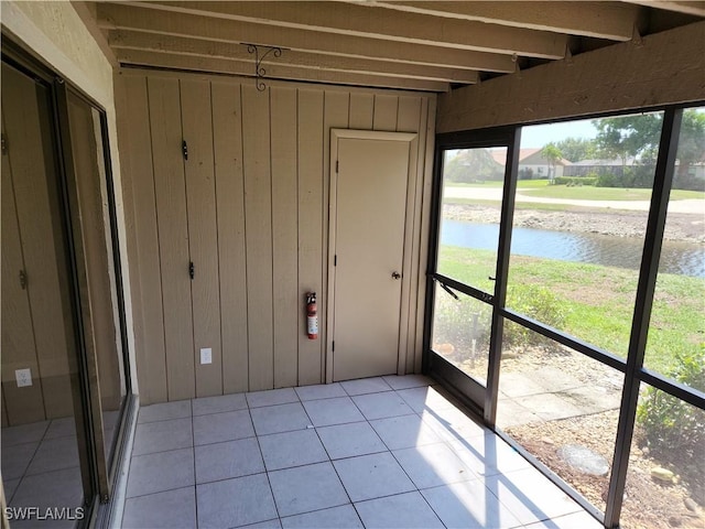 unfurnished sunroom featuring a water view