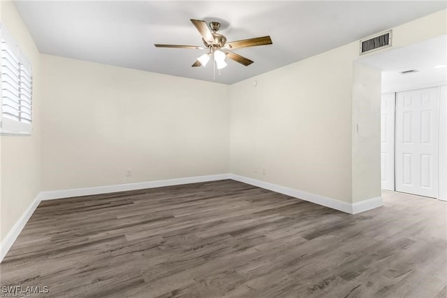 spare room with dark hardwood / wood-style floors and ceiling fan