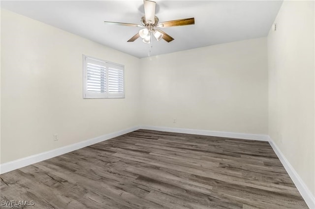 spare room featuring dark hardwood / wood-style flooring and ceiling fan