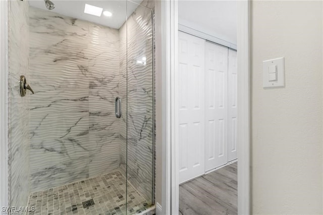 bathroom with hardwood / wood-style flooring and an enclosed shower