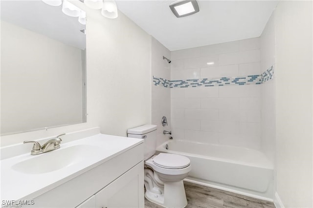 full bathroom with hardwood / wood-style flooring, tiled shower / bath combo, toilet, and vanity