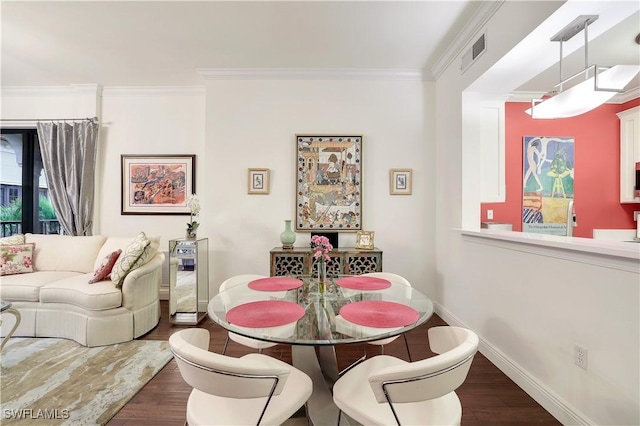 dining space with dark wood finished floors, visible vents, crown molding, and baseboards