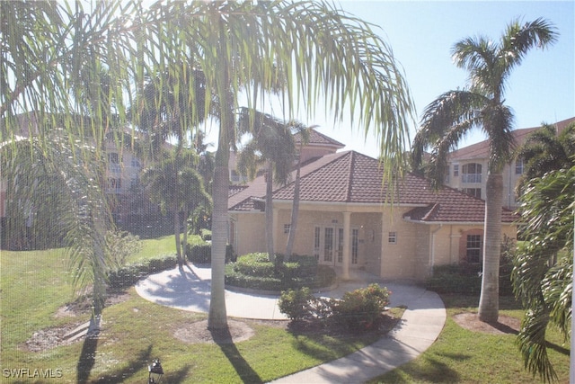 view of front facade with a front lawn and french doors