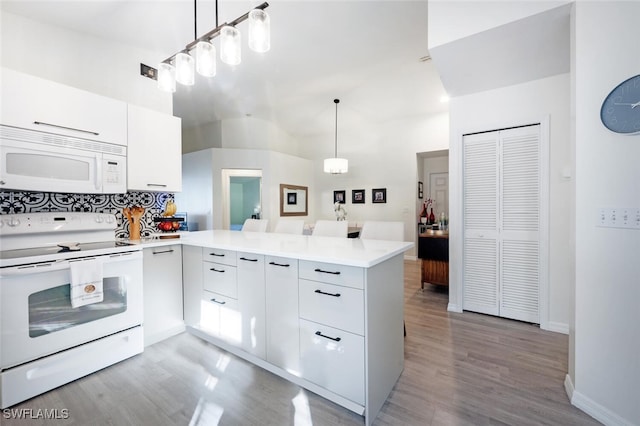 kitchen with kitchen peninsula, decorative light fixtures, and white appliances