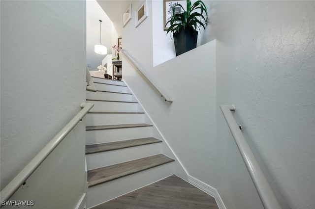 staircase with hardwood / wood-style floors