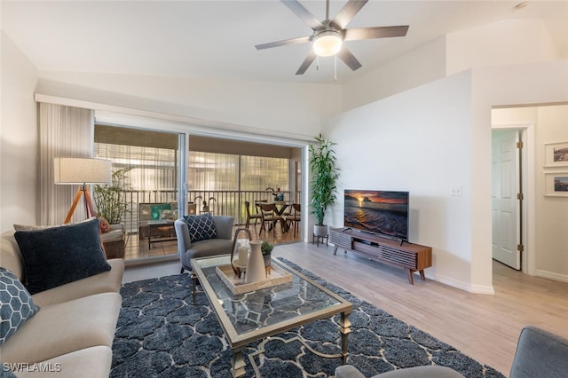 living room featuring ceiling fan, plenty of natural light, vaulted ceiling, and hardwood / wood-style flooring