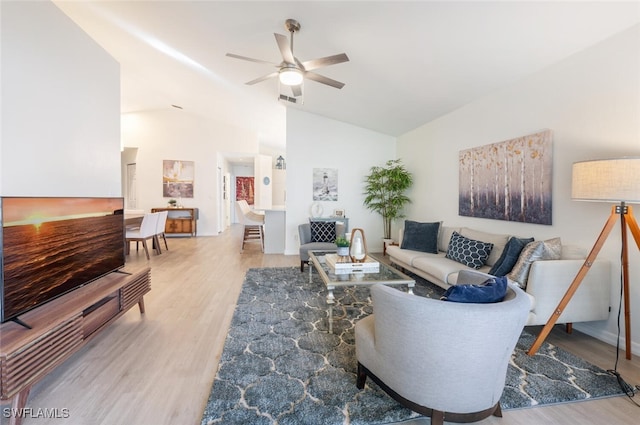 living room with wood-type flooring, vaulted ceiling, and ceiling fan