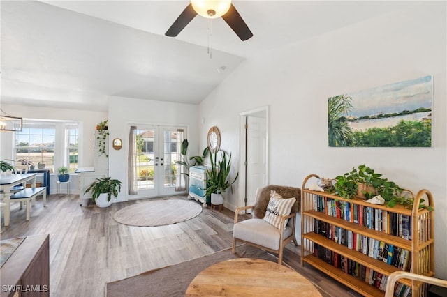 sitting room with lofted ceiling, hardwood / wood-style floors, plenty of natural light, and french doors