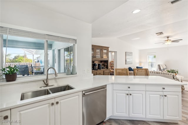 kitchen featuring dishwasher, sink, kitchen peninsula, and white cabinets