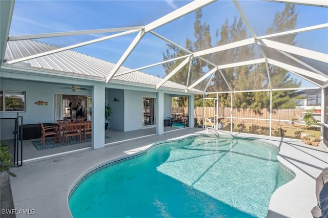 view of swimming pool with a patio, ceiling fan, and glass enclosure