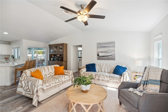 living room with ceiling fan, lofted ceiling, wood-type flooring, and sink