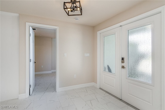 foyer entrance with a chandelier and french doors