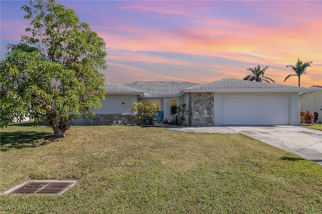 ranch-style home with a garage and a lawn