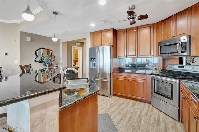 kitchen featuring light wood-type flooring, hanging light fixtures, a breakfast bar area, and appliances with stainless steel finishes