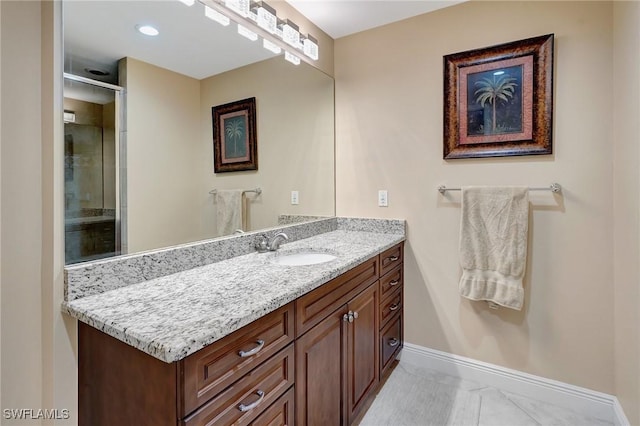 bathroom with a shower with door and vanity