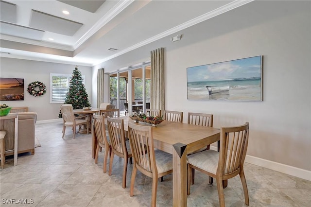 dining room featuring a raised ceiling and crown molding