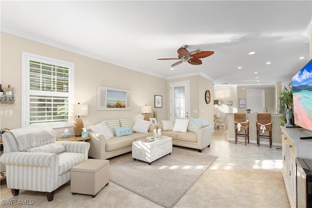 living room with ceiling fan, a healthy amount of sunlight, light tile patterned floors, and crown molding