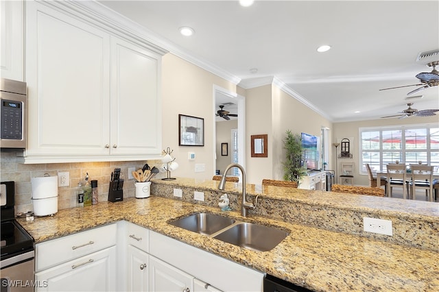 kitchen featuring white cabinets, stainless steel appliances, kitchen peninsula, and sink