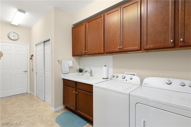 clothes washing area featuring washer and clothes dryer, cabinets, light tile patterned floors, and sink