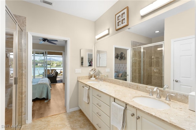 bathroom with tile patterned flooring, vanity, a shower with door, and ceiling fan