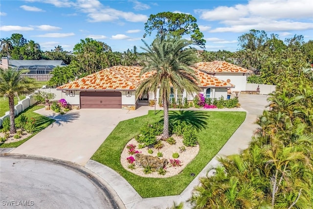 mediterranean / spanish home with a front lawn and a garage