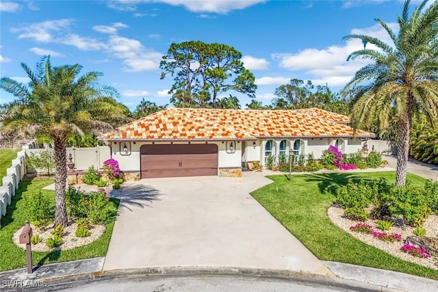 mediterranean / spanish-style home featuring a garage and a front lawn