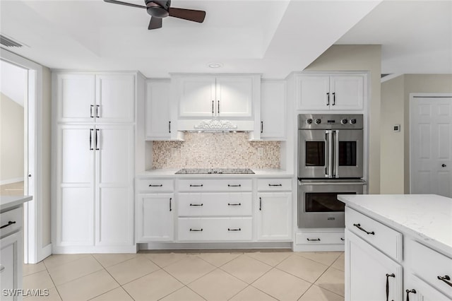 kitchen featuring white cabinets, black electric stovetop, double oven, and tasteful backsplash