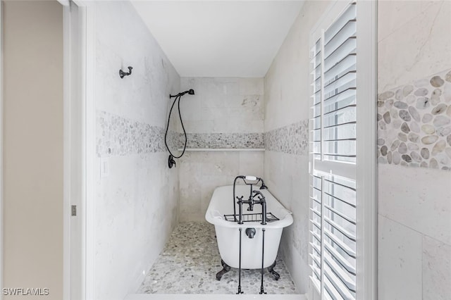 bathroom with a bathtub and tile walls