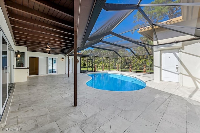 view of pool featuring glass enclosure, ceiling fan, and a patio area