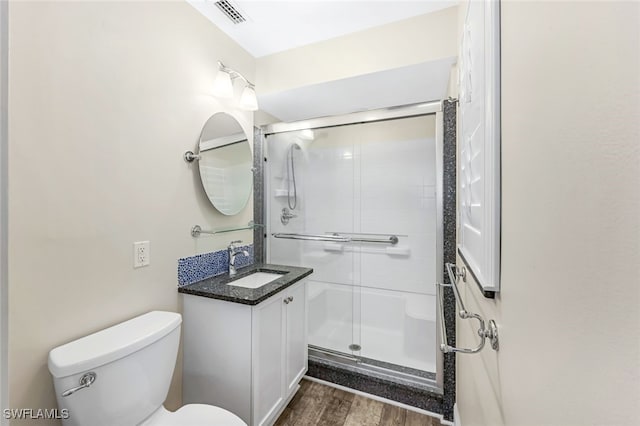 bathroom featuring hardwood / wood-style floors, vanity, toilet, and walk in shower