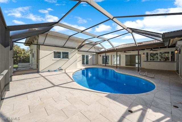 view of pool with glass enclosure, ceiling fan, and a patio area