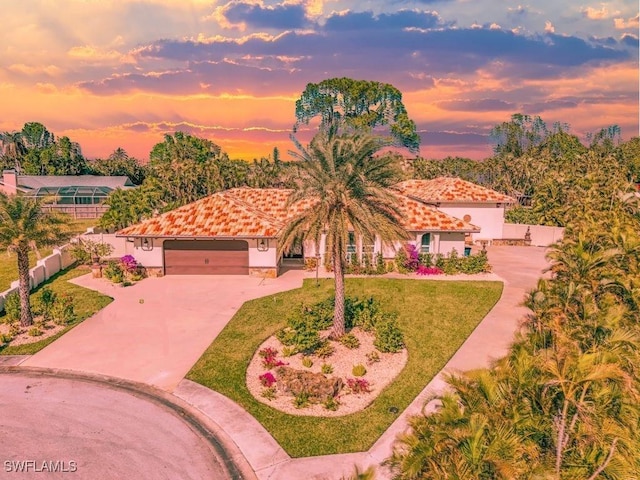 mediterranean / spanish-style home with a yard and a garage