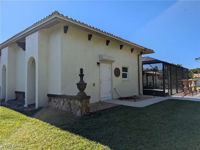 back of property with a lanai, a lawn, and a patio