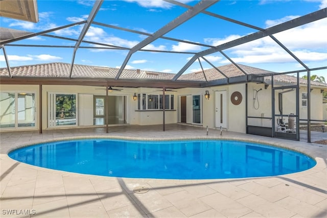 view of pool with ceiling fan, a lanai, and a patio