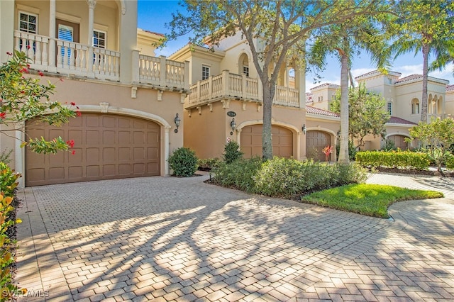 view of front of property featuring a balcony and a garage