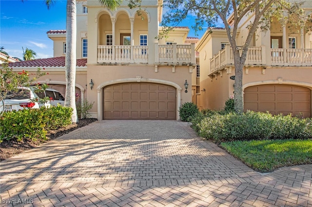 mediterranean / spanish-style home featuring a garage and a balcony