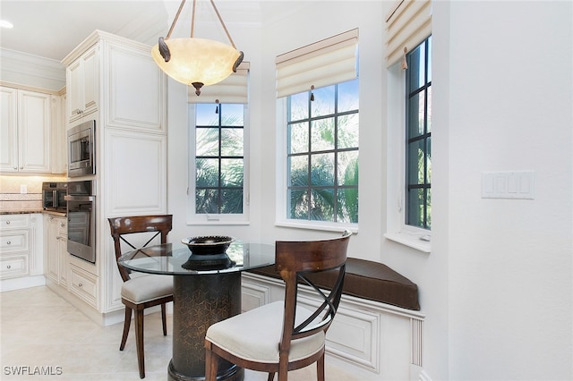 tiled dining area featuring crown molding