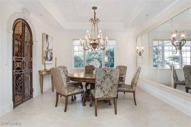 tiled dining area with ornamental molding, a raised ceiling, and a chandelier